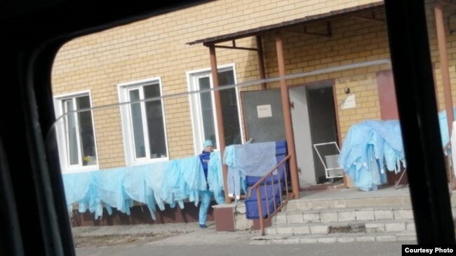 Семейдегі жедел жәрдем станциясында бір-ақ рет пайдалануға жарайтын медициналық қорғаныш киімін жайып, кептіріп жүрген адам. 2 қараша 2020 жыл. Фото авторы - Сәуле Төлеутайқызы.