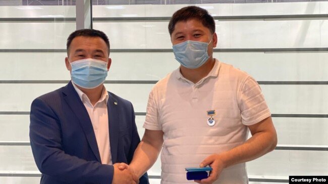 Ербол Мандибек (справа) получает награду как журналист гостелеканала Qazaqstan.