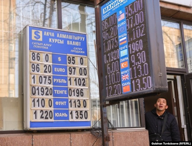 Мужчина смотрит на табло обменного пункта на улице Элебесова (Советской) в Бишкеке. 24 февраля 2022 года
